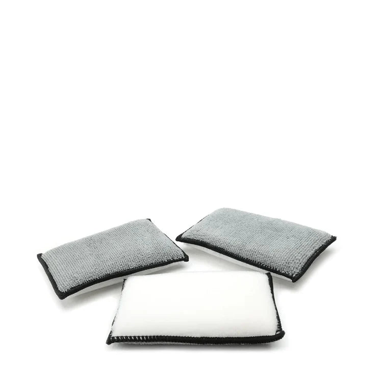 Three Scrub Ninja cleaning pads with gray and white surfaces and black edging